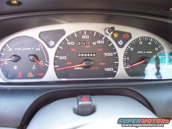Dashboard with speedometer, tachometer, fuel gauge, and warning lights. Odometer shows 090449