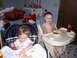 1983 Ford Bronco - Two young children are seated in high chairs and eating their meals in a messy indoor setting.