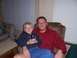 1983 Ford Bronco - A man and a boy sit together in a room, the boy holding a cell phone.