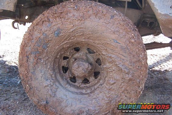 Mud-caked tire and wheel assembly of an off-road vehicle
