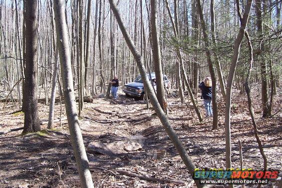 Dark blue SUV on a muddy forest trail
