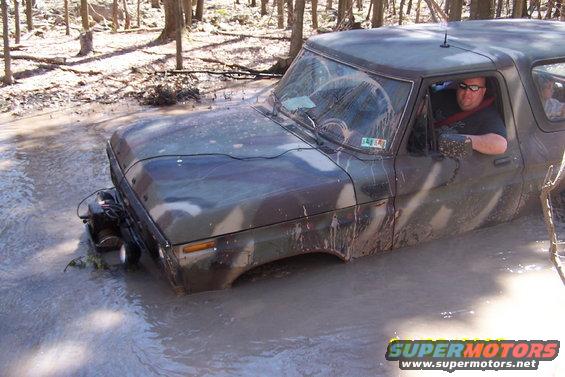 1979 Ford Bronco in mud, front 3/4 view, camouflage paint