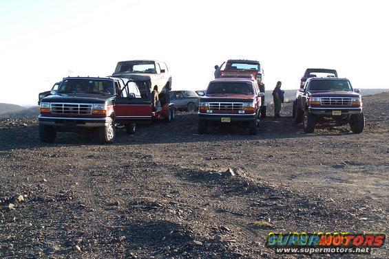 Several Ford trucks and SUVs parked on a rocky terrain