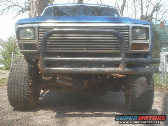 Blue pickup truck front end with bull bar and grille