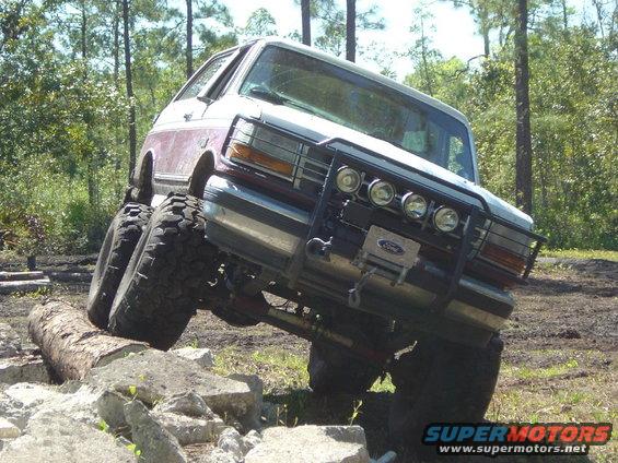 Ford Bronco going over rocks and logs, front end lifted