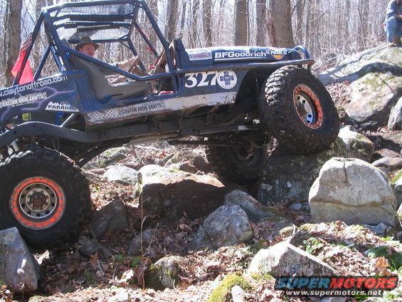 Off-road buggy with roll cage and BFGoodrich tires navigating rocky terrain
