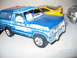 1986 Ford Bronco - A collection of toy vehicles are displayed on a flat surface.