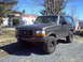 1993 Ford Bronco - This gray 1993 Ford Bronco is equipped with off-road tires and appears to be parked in a residential driveway.