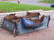 1948 Mercury M 100 - Discarded and heavily rusted truck bed components are piled on a paved surface.