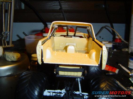Model truck bed with large tires and suspension parts visible