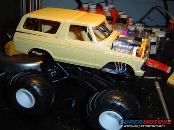 model truck body on monster truck chassis with chrome engine and exhaust pipes