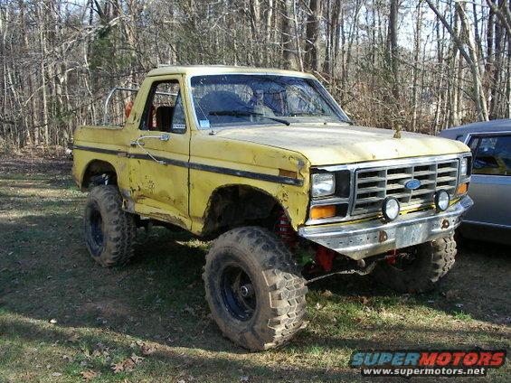 Yellow lifted truck, 3q-front view. Modified for off-road use