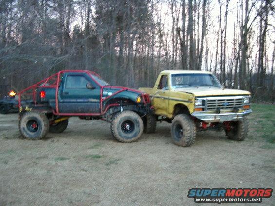 Yellow Ford truck with custom roll cage and green truck with roll cage, side view