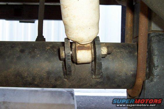 Close-up of a rear axle shock mount with a white shock absorber attached