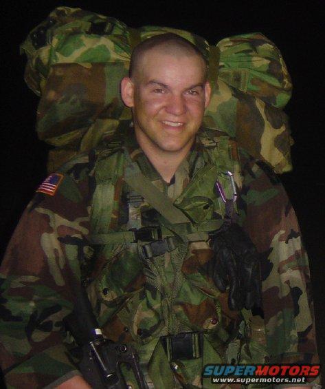 Soldier in camouflage uniform with large backpack and rifle