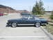 1990 Ford Crown Victoria - A 1990 Ford Crown Victoria sedan is parked in a lot, showing its side profile.