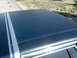 1990 Ford Crown Victoria - A close-up view of the dark vinyl top and chrome trim of a vehicle.