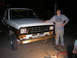 1986 Ford Bronco II - A person stands next to a white and brown Ford Ranger pickup truck at night.