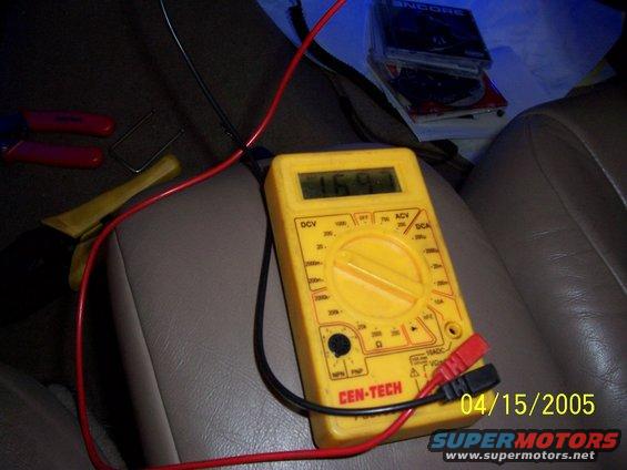Interior view of a car with a yellow multimeter and tools on a leather seat