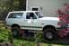 1987 Ford Bronco - This 1987 Ford Bronco is parked in a residential setting with trees and a house in the background.
