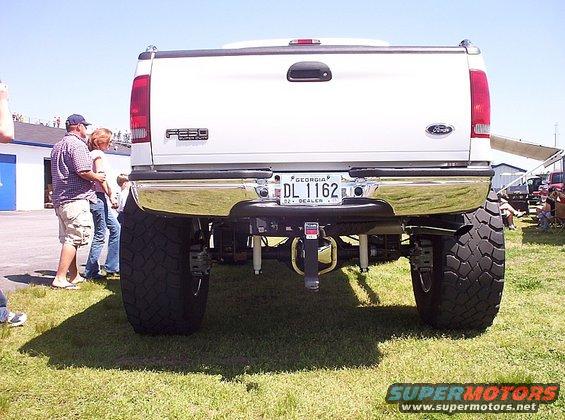 Rear view of a lifted white Ford F-Series truck with large tires and a chrome bumper. Georgia license plate DL 1162 is visible