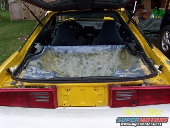 yellow sports car's interior, rear seats visible, cargo area stripped down