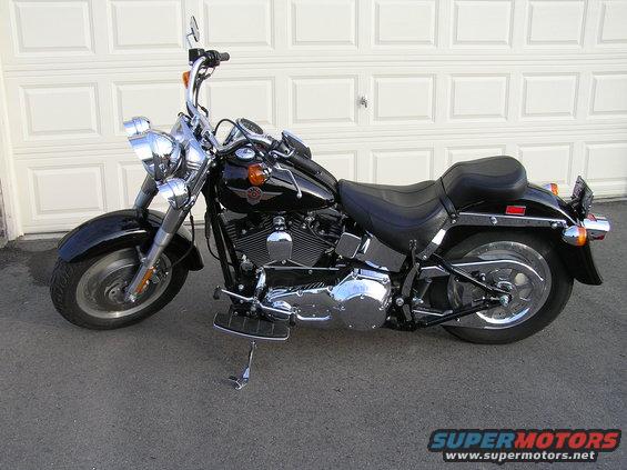 Black Harley-Davidson Fat Boy motorcycle parked in front of a garage door
