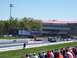 1978 Ford F-250 - Cars line up at the start of a drag race, with spectators in the foreground and a grandstand in the background.