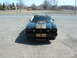 1978 Ford Mustang II - Front view of a black 1978 Ford Mustang II, gold racing stripes and a Cobra emblem.