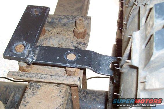 Black metal bracket attached to rear axle near tire