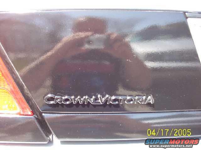 Crown Victoria badge on a dark car's trunk lid, with a date stamp of 04/17/2005