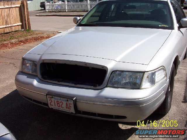 Silver sedan front view, missing grille. License plate 2182 AF