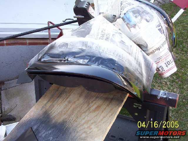 Car fender covered in newspaper, resting on sawhorses. Date stamp reads 04/16/2005