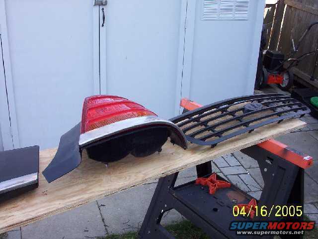 Car grille and taillight assembly on a workbench with a date stamp of 04/16/2005