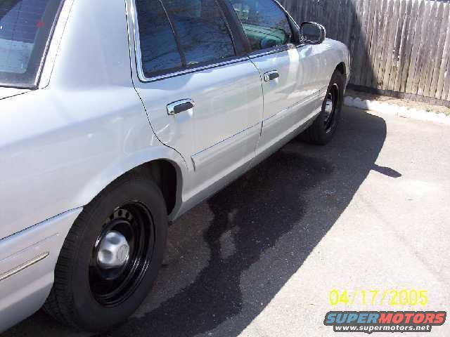 Silver sedan side view, black steel wheels, chrome door handles, tinted windows