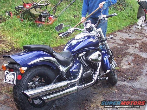 Blue motorcycle rear view with chrome exhaust and license plate