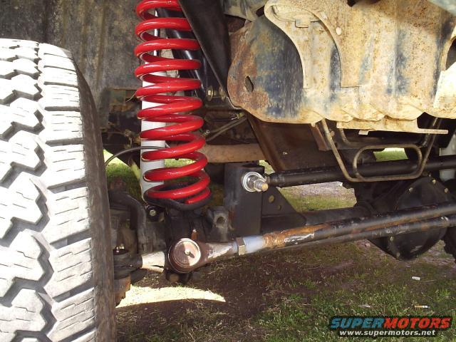 Close-up of a red coil spring and suspension components on an off-road vehicle