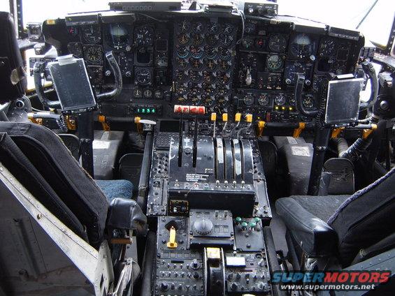 Airplane cockpit with many gauges, levers, and two seats