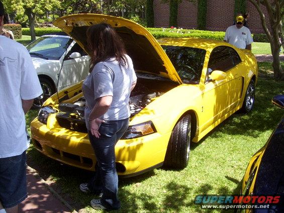 Yellow Ford Mustang with hood open, viewed from the front-right