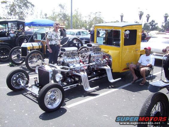 Yellow hot rod with dual V8 engines and exposed exhaust pipes