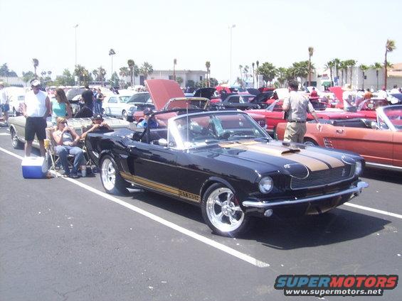 Black 1967 Shelby GT500 convertible with gold stripes and chrome wheels