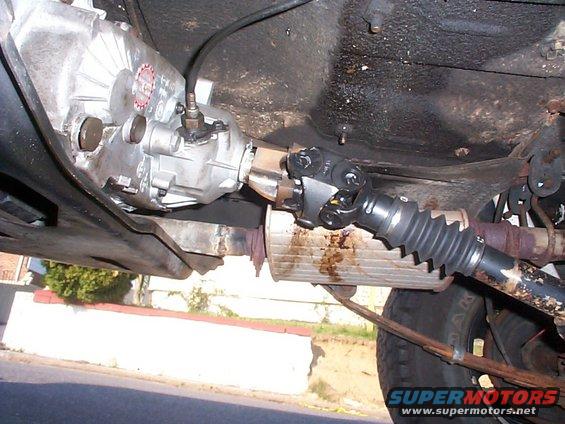 Underbody view of transmission and driveshaft with a red circular sticker on the transmission