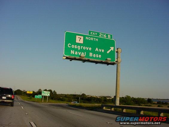 Highway sign for Exit 216B, Cosgrove Ave, Naval Base North. SUV on left, other cars on road
