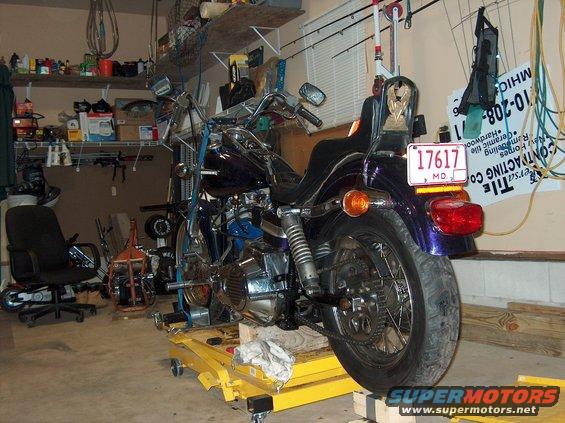 Purple 1976 Harley-Davidson Super Glide motorcycle on a yellow lift, rear view. License plate reads 17617 MD