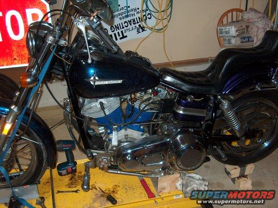 Harley-Davidson motorcycle on a yellow lift, blue engine covers, chrome details