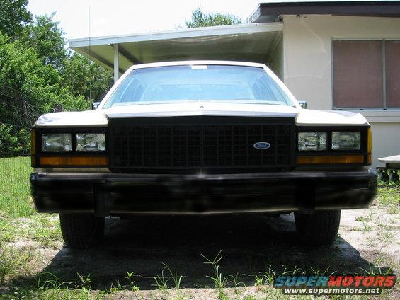 Front view of a white 1985 Ford Crown Victoria LTD parked outside a house