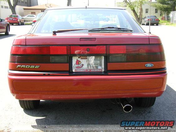 Rear view of a red 1991 Ford Probe with a University of Louisville license plate frame