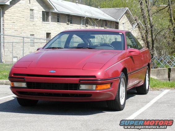 Red 1991 Ford Probe parked outside a stone building