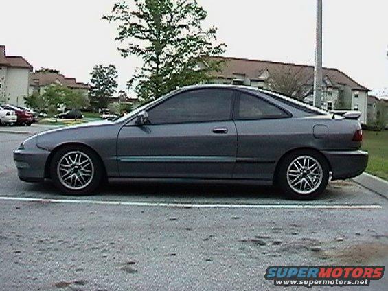 Side view of a dark gray coupe with tinted windows and a spoiler