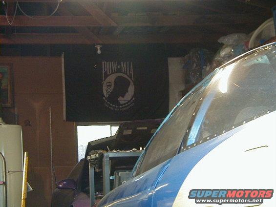 Blue and white vehicle interior with a POW-MIA flag in the background
